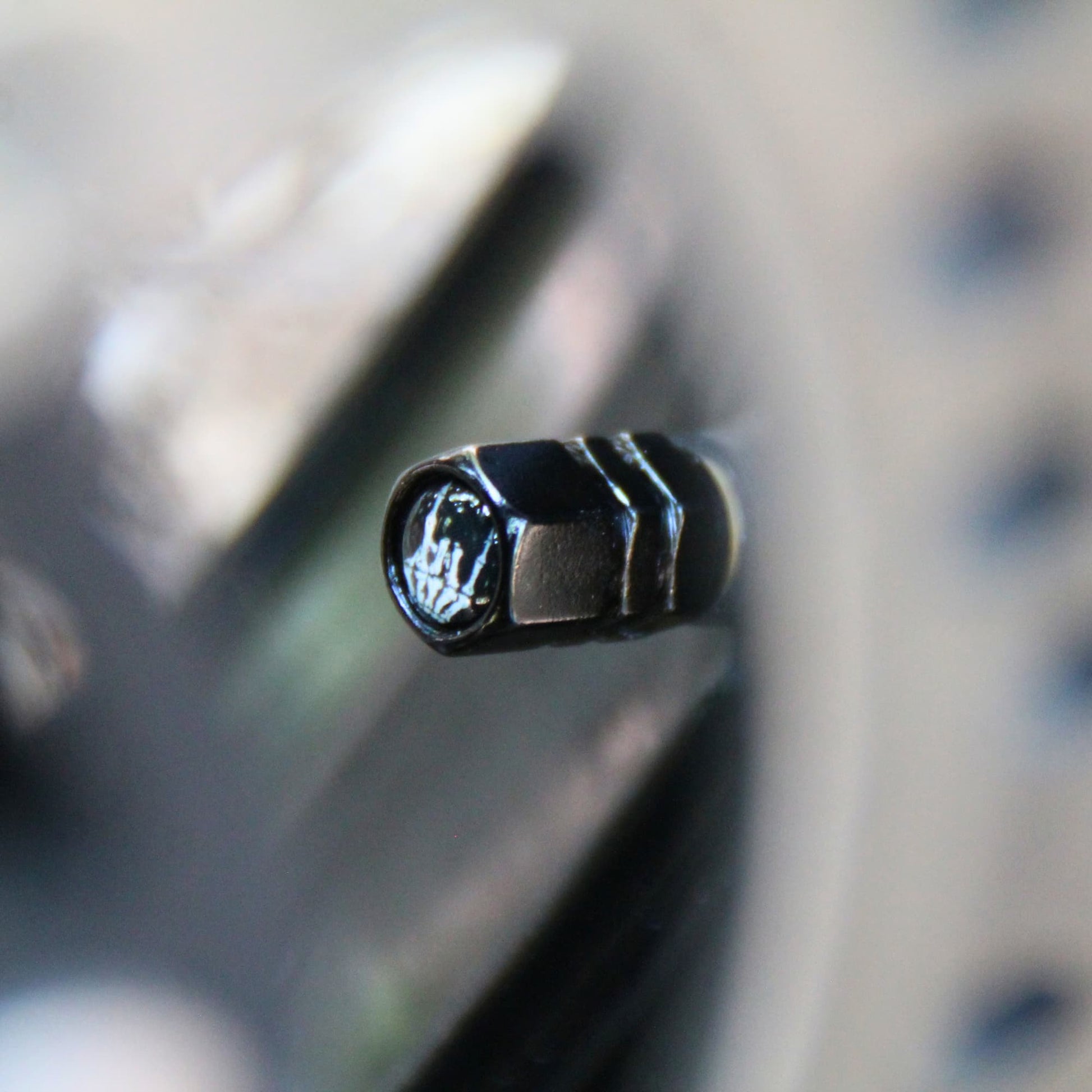 Bouchons de valve moto noirs design signe Rock main squelette.
