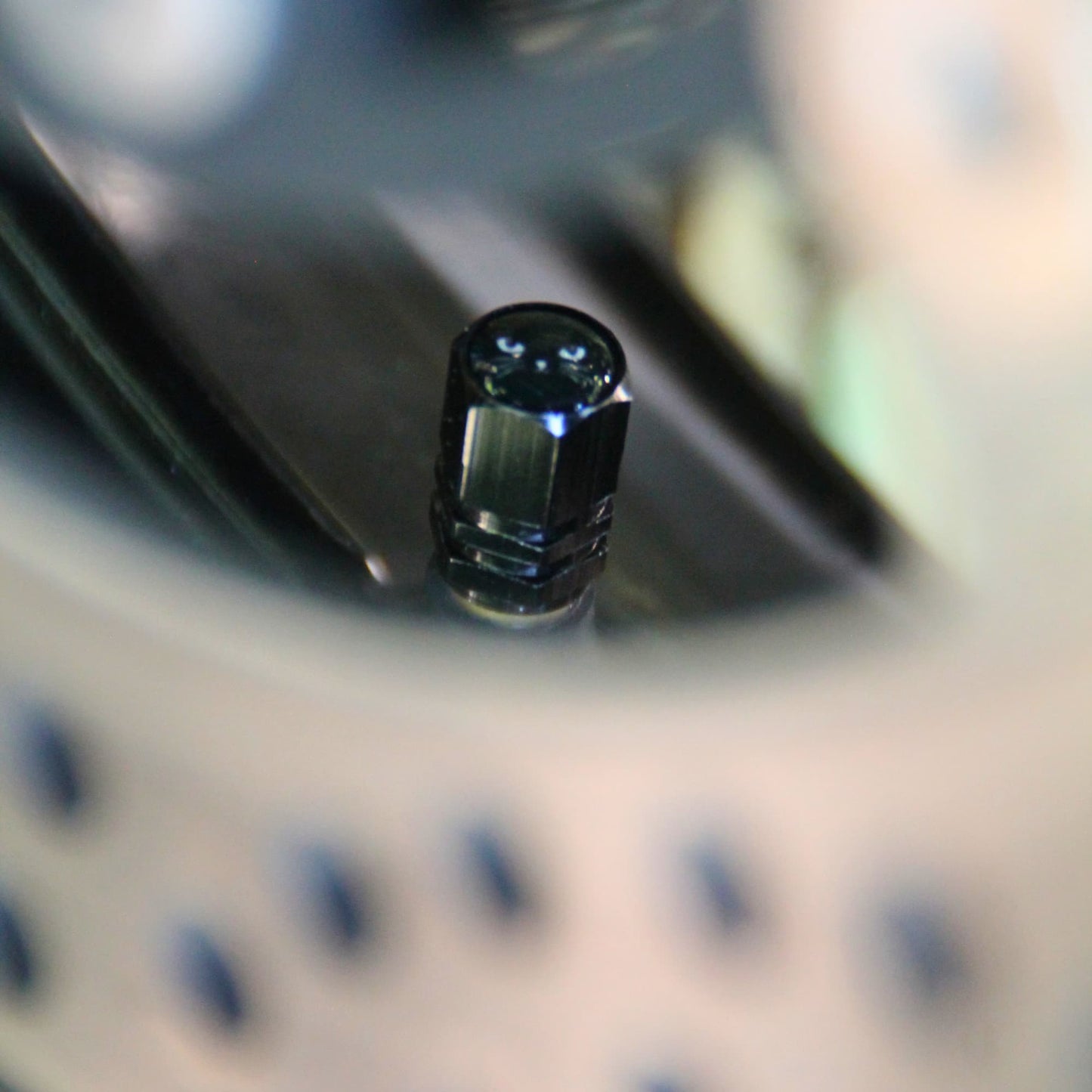Zoom sur les bouchons de valve moto noirs tete de chat.