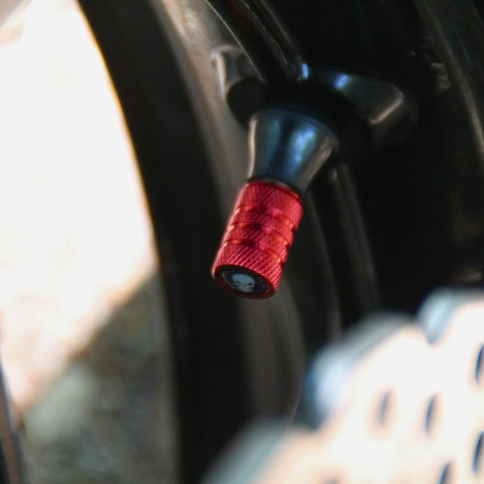 Zoom sur les bouchons de valve moto rouges et crâne.