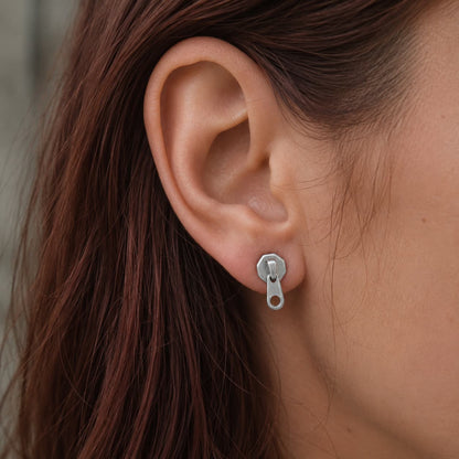 Boucles d'oreilles zip fermeture eclair en acier inox argenté portées par une motarde