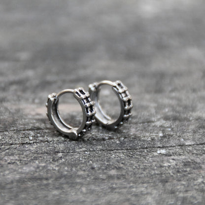 Boucles d'oreilles mini créoles en acier inoxydable en forme de chaine de moto. Anneau fermé.