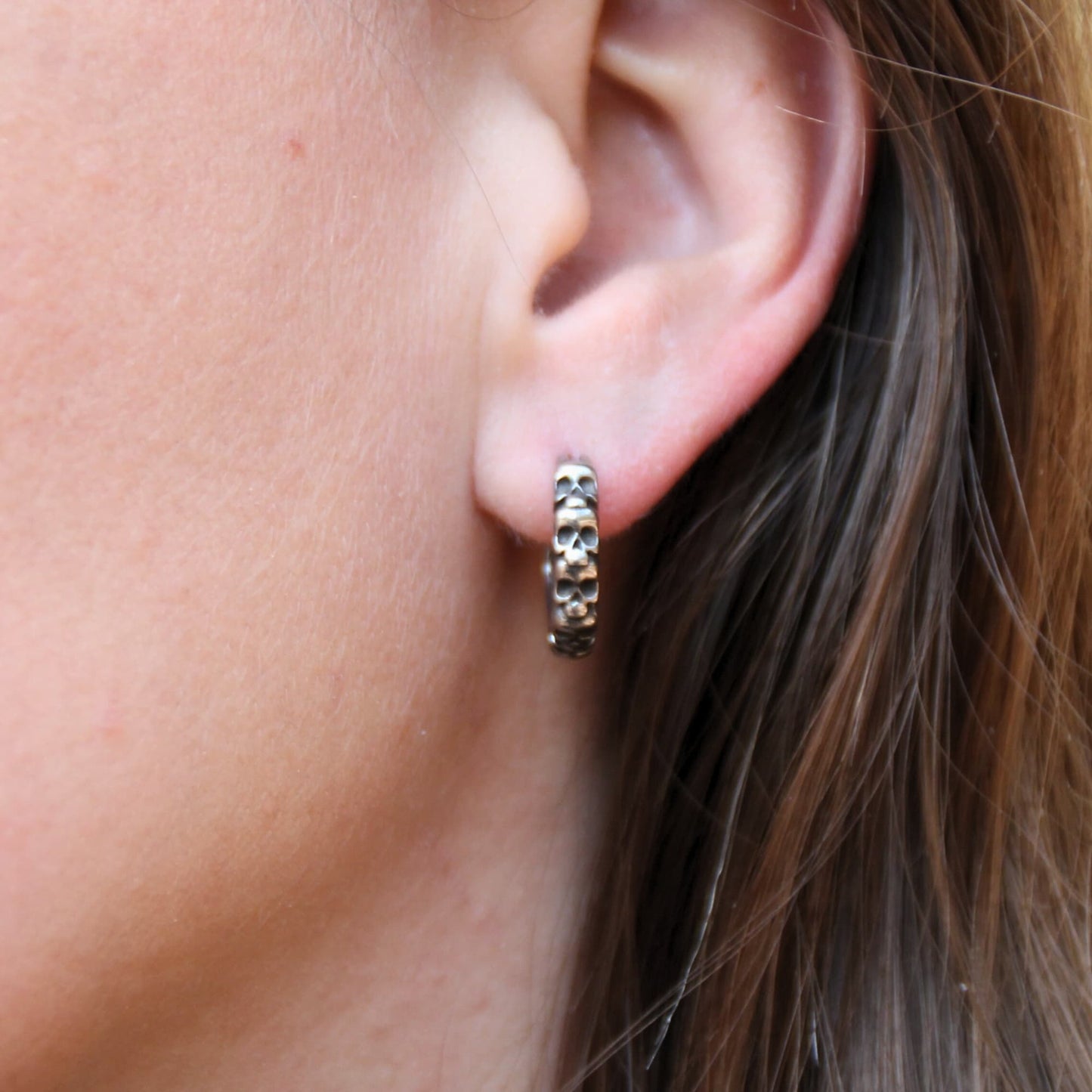 Boucles d'oreilles mini créoles en acier inox crânes. Anneau fermé.