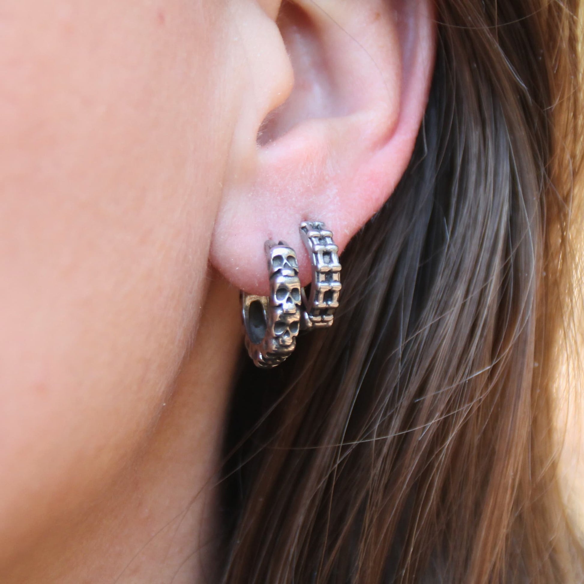 Duo de boucles d'oreilles mini créoles en acier inox en chaine de moto et crânes. Anneaux fermés.
