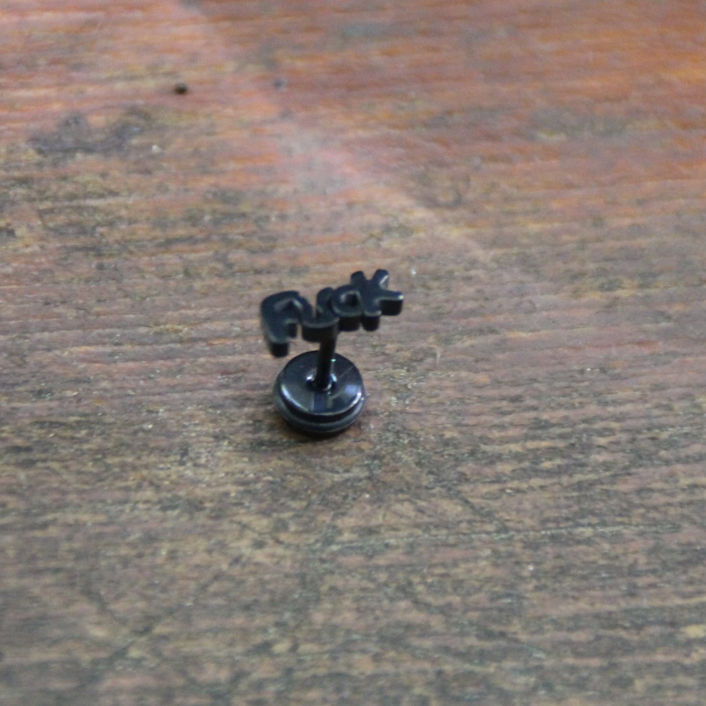 Boucles d'oreilles fuck en acier inoxydable noir. Embout plat et vissé parfait pour motard