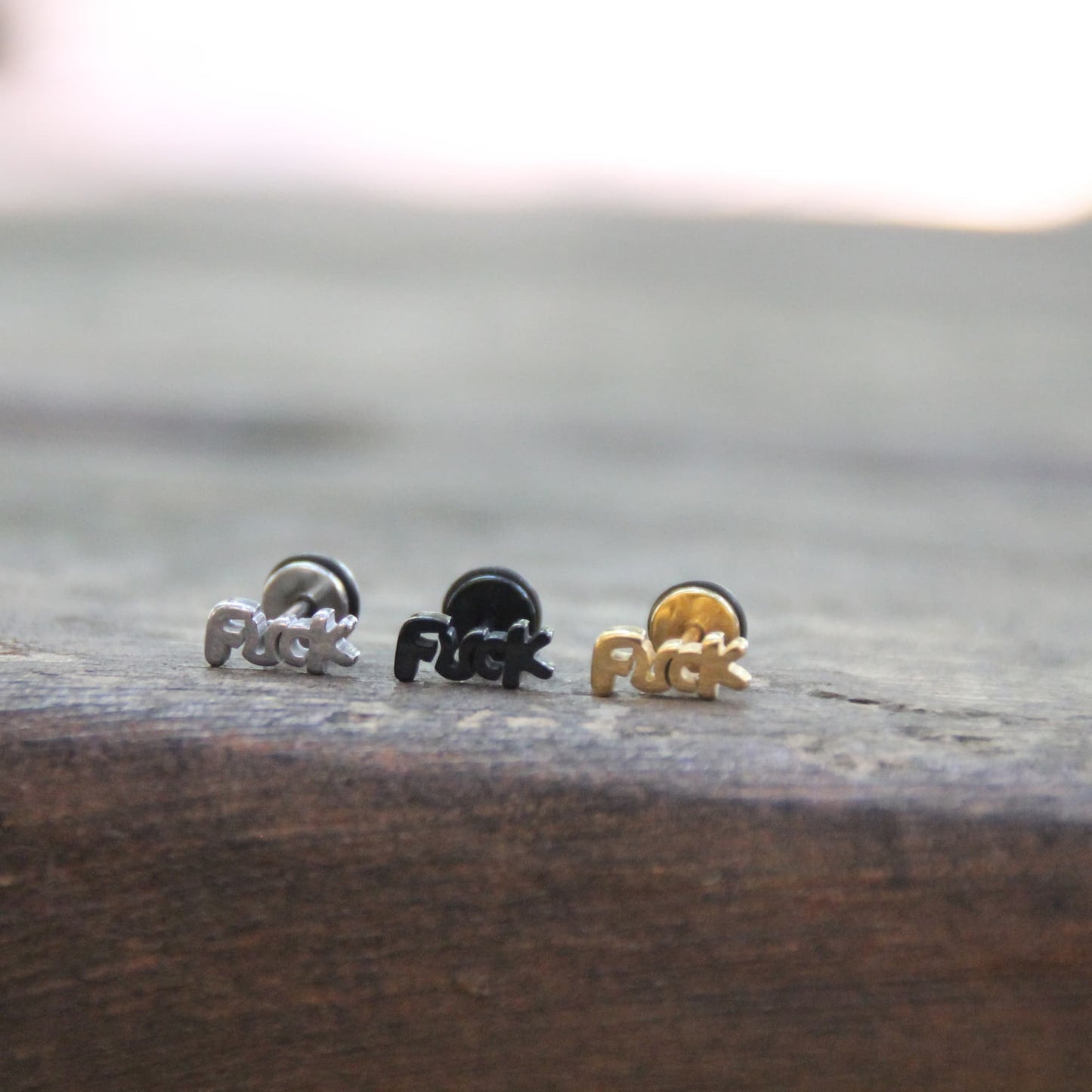 Boucles d'oreilles fuck en acier inoxydable. Embout plat parfait sous un casque de moto.