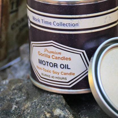 Gros plan sur la bougie parfumée "huile moteur", cire lisse et beige dans un pot en métal, ambiance garage vintage.