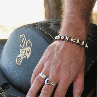 Bracelet et bague pour motard posé sur une selle de moto.