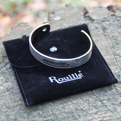 Bracelet jonc en acier inoxydable argenté de la marque Rouille, présenté avec sa pochette en velours noir élégant.