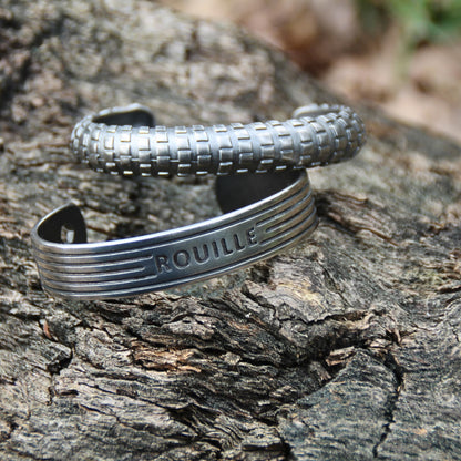 Deux bracelets joncs en acier inoxydable argenté de la marque Rouille – Un design inspiré d’un pneu et d’un moteur pour un look audacieux.
