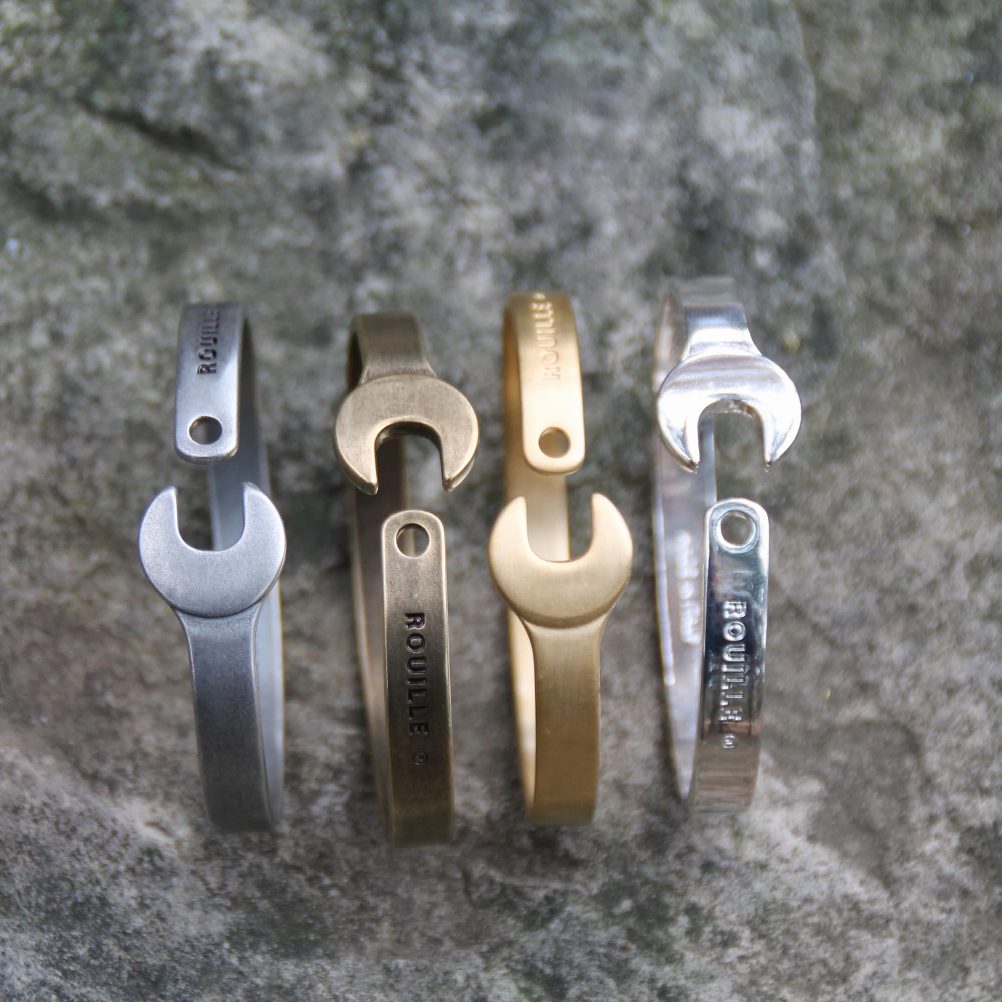 Bracelets joncs en acier inoxydable de la marque Rouille. Ils représentent une clé plate et son proposés en 4 coloris.