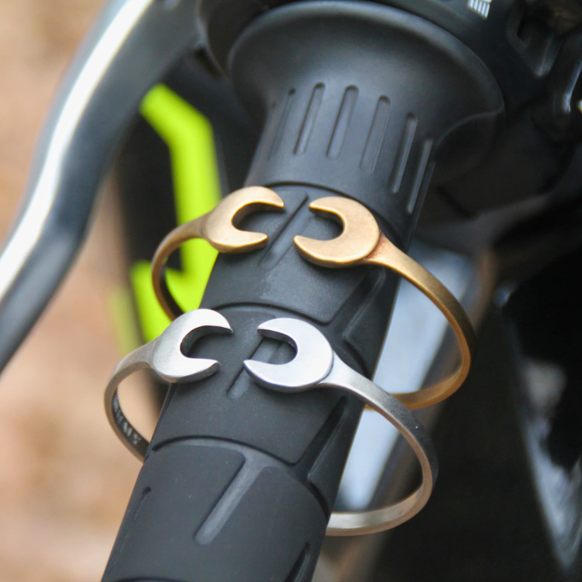 Bracelets joncs en acier inoxydable en forme de double clé plate de la marque italienne Rouille. ils sont proposés en argent vintage ou doré vintage