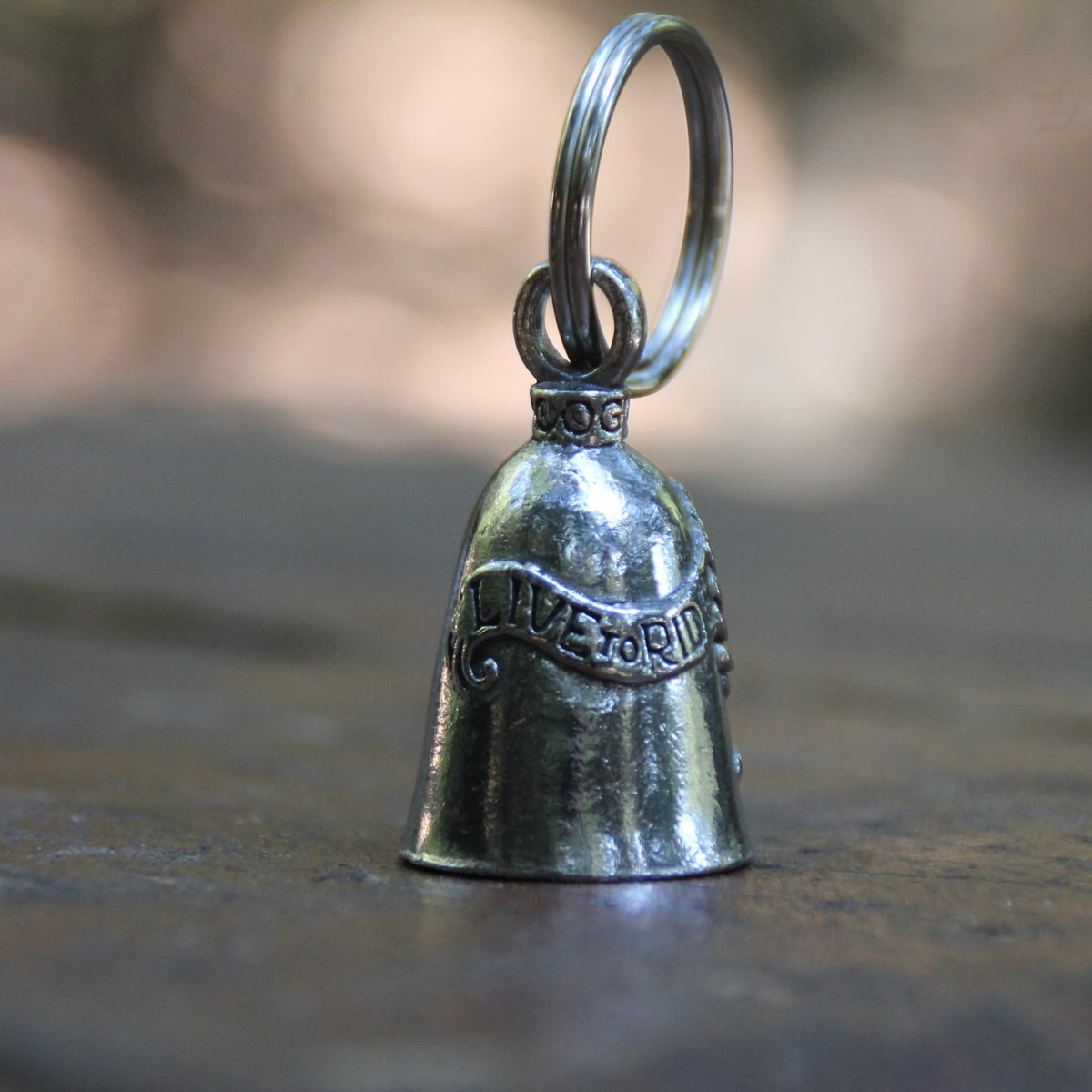 Clochette moto Guardian Bell Live to Ride, Ride to Live, devise de motard inscrite sur l'étain, porte-bonheur officiel vue de dos.