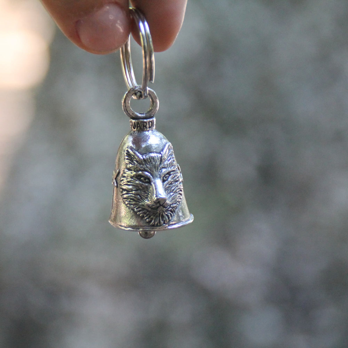 Clochette moto Guardian Bell loup tenue en main