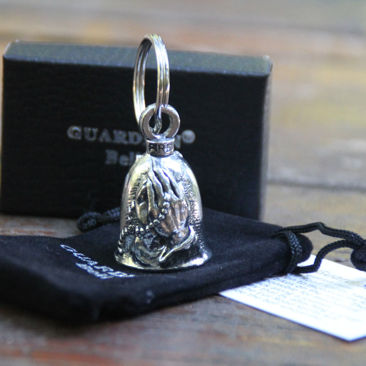 Guardian Bell Mains en prière, mains jointes et chapelet avec croix, en étain avec sa pochette en velours noir et sa carte de la légende