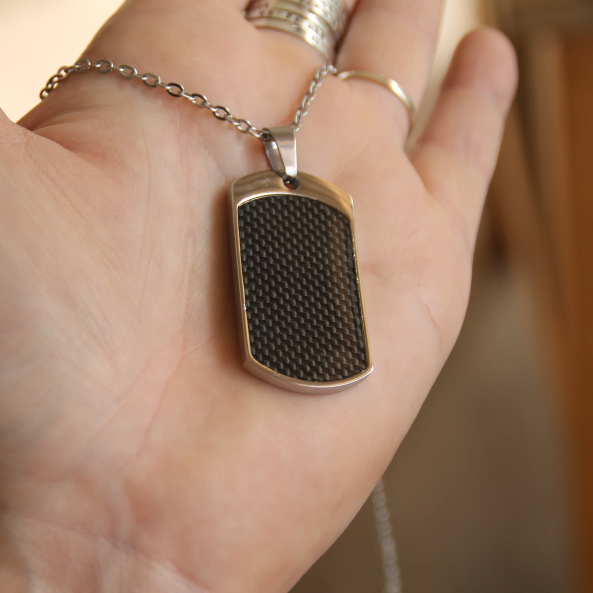 Beau collier motard en acier inoxy et pendentif incrusté de fibre de carbone