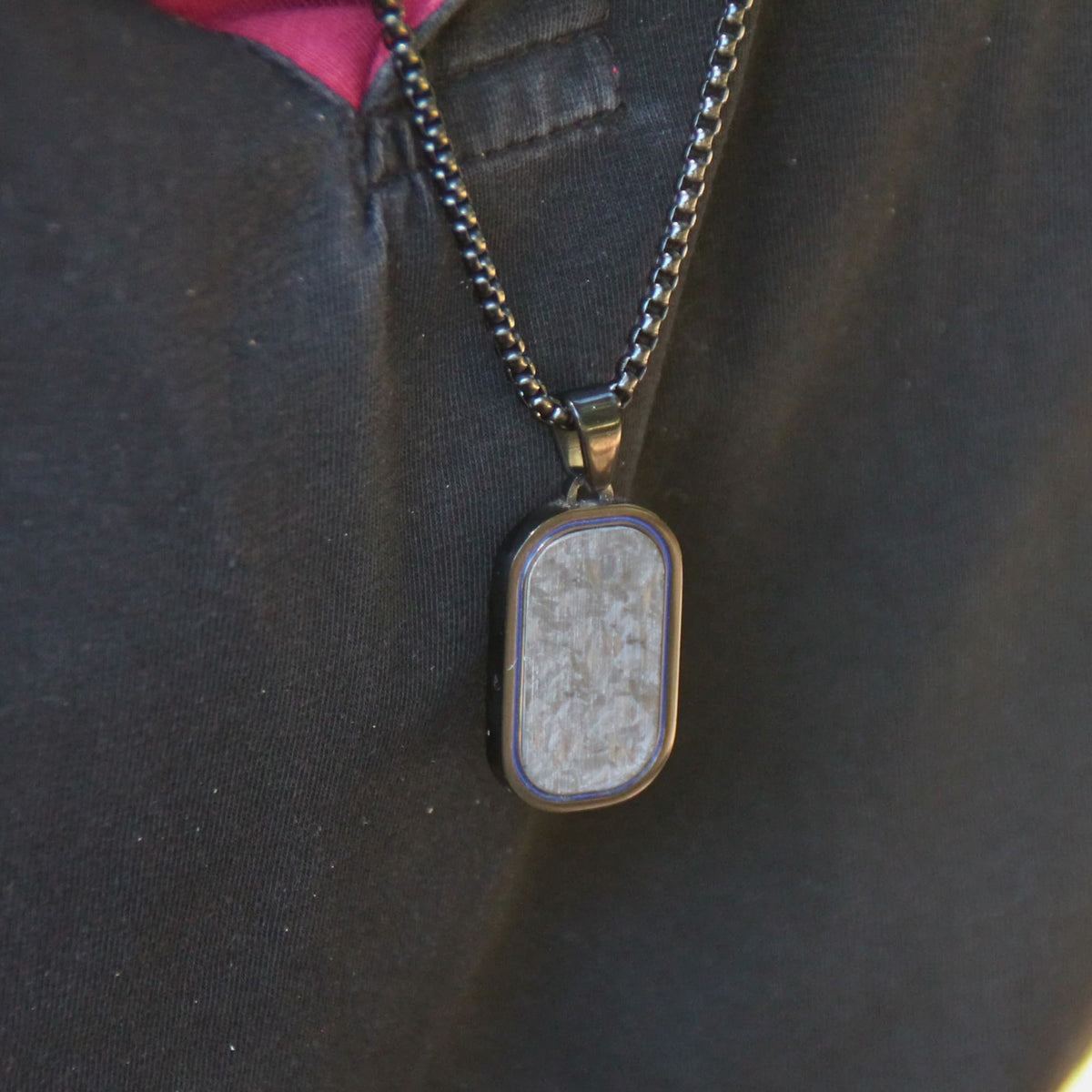 Collier motard en acier inox et pendentif carbone noir porté.