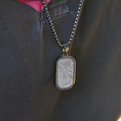 Collier motard en acier inox et pendentif carbone noir porté.