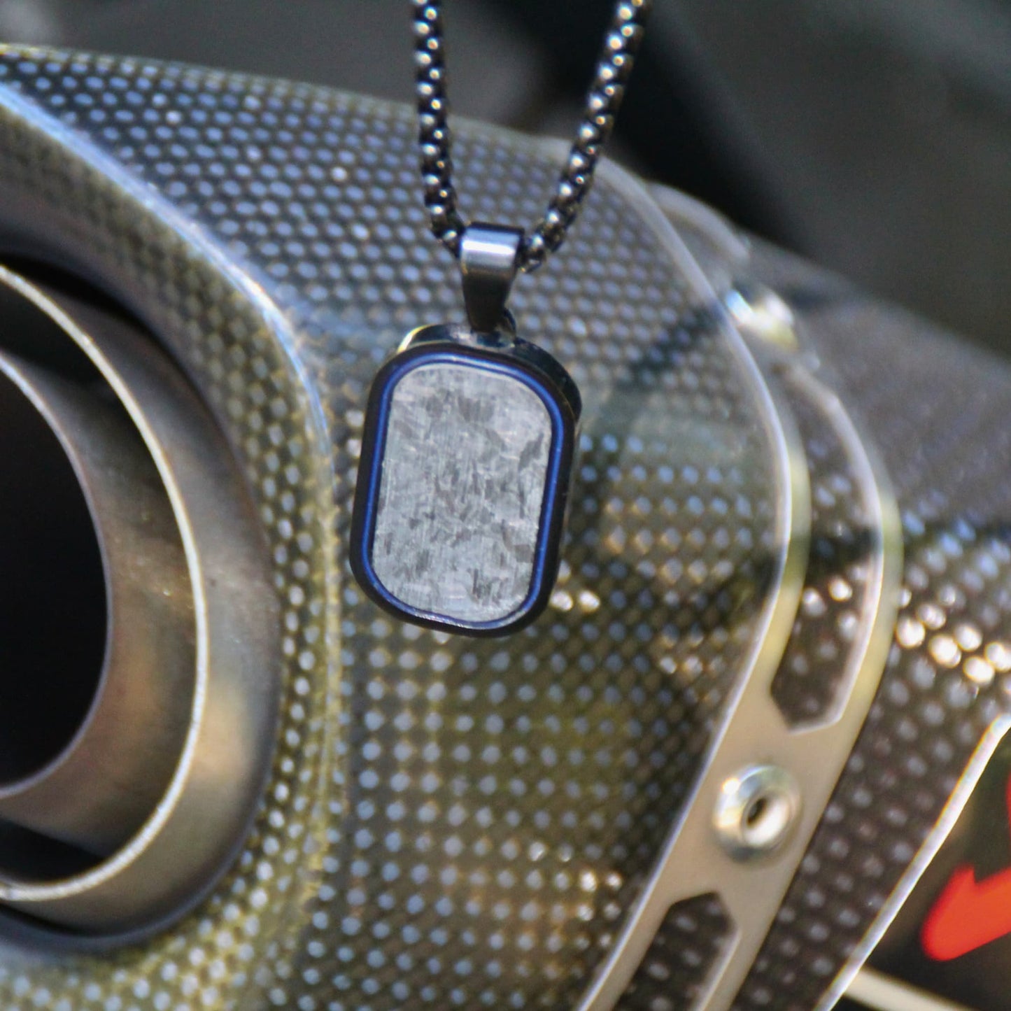 Collier motard en acier inox et pendentif carbone noire texturé. 
