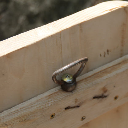 Crochet de fixation mural au dos du support de casque moto.