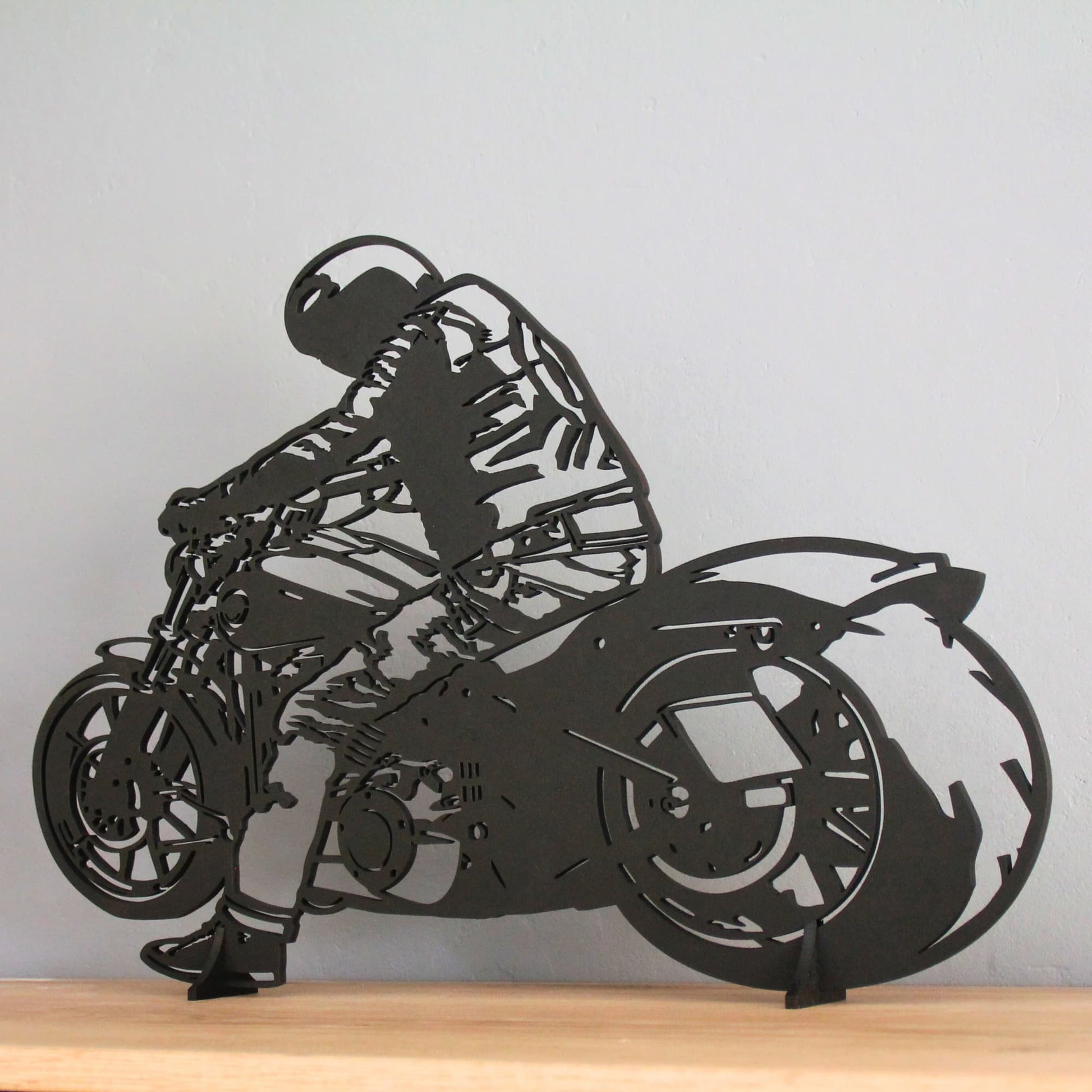 Tableau biker noir sur sa moto exposé sur un mur  gris – style épuré et moderne.