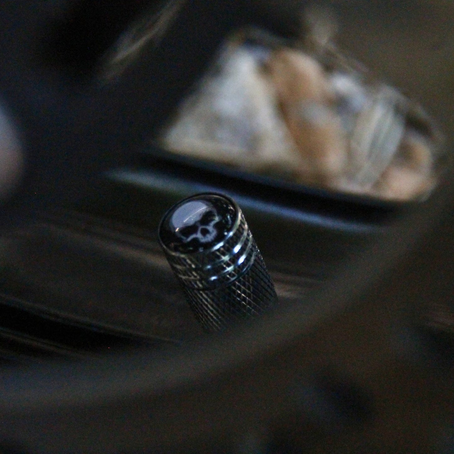Zoom sur les bouchons de valve moto gris bleuté et crâne. 