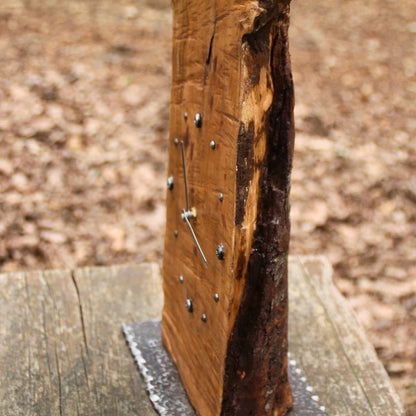 Vue de profile sur le bois brut naturel de l'horloge en cerisier. Coupe brute, irrégulière, unique. 