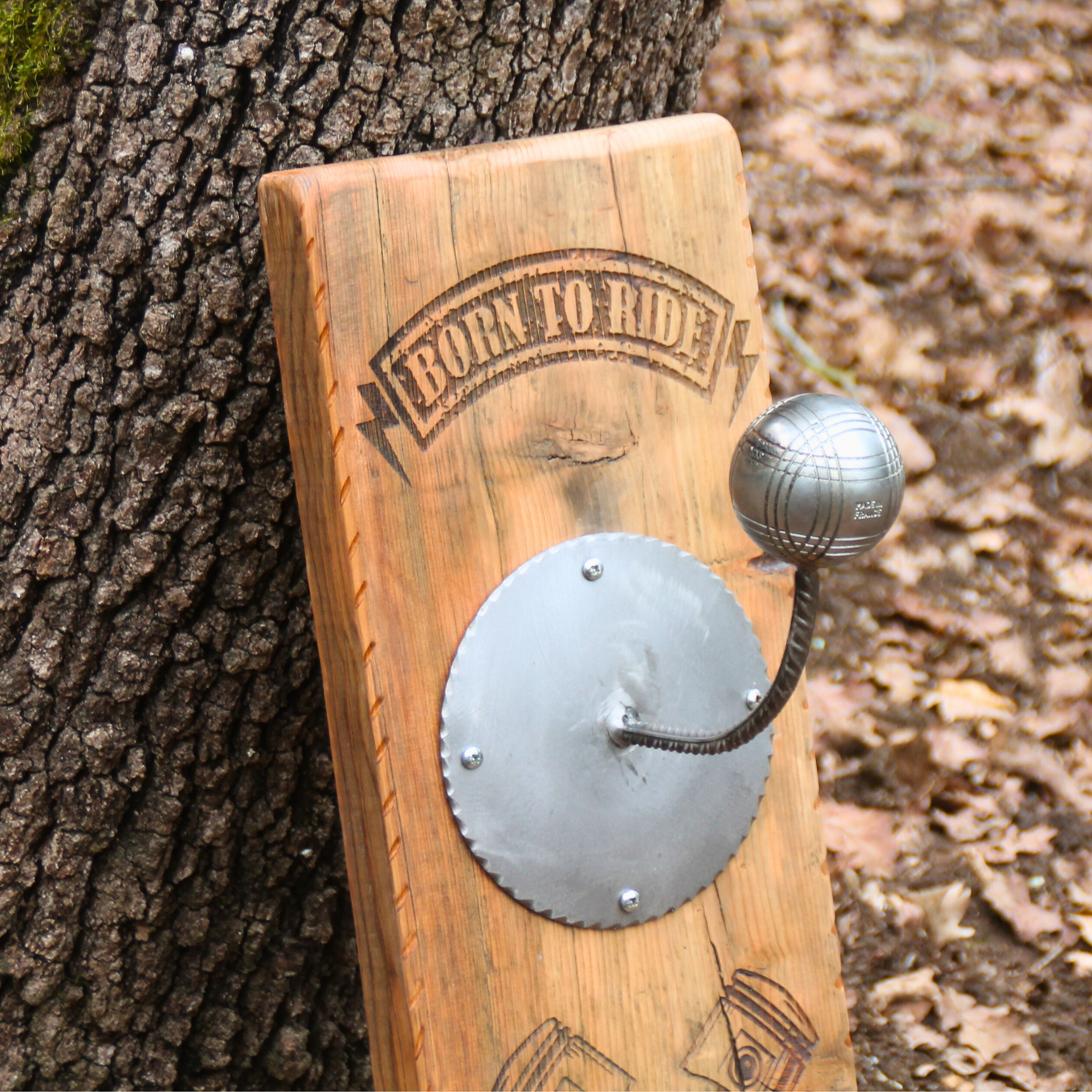 Zoom détaillé sur repose-casque boule pétanque stable et gravure pistons – protection mousses garantie sur porte casque moto mural artisanal