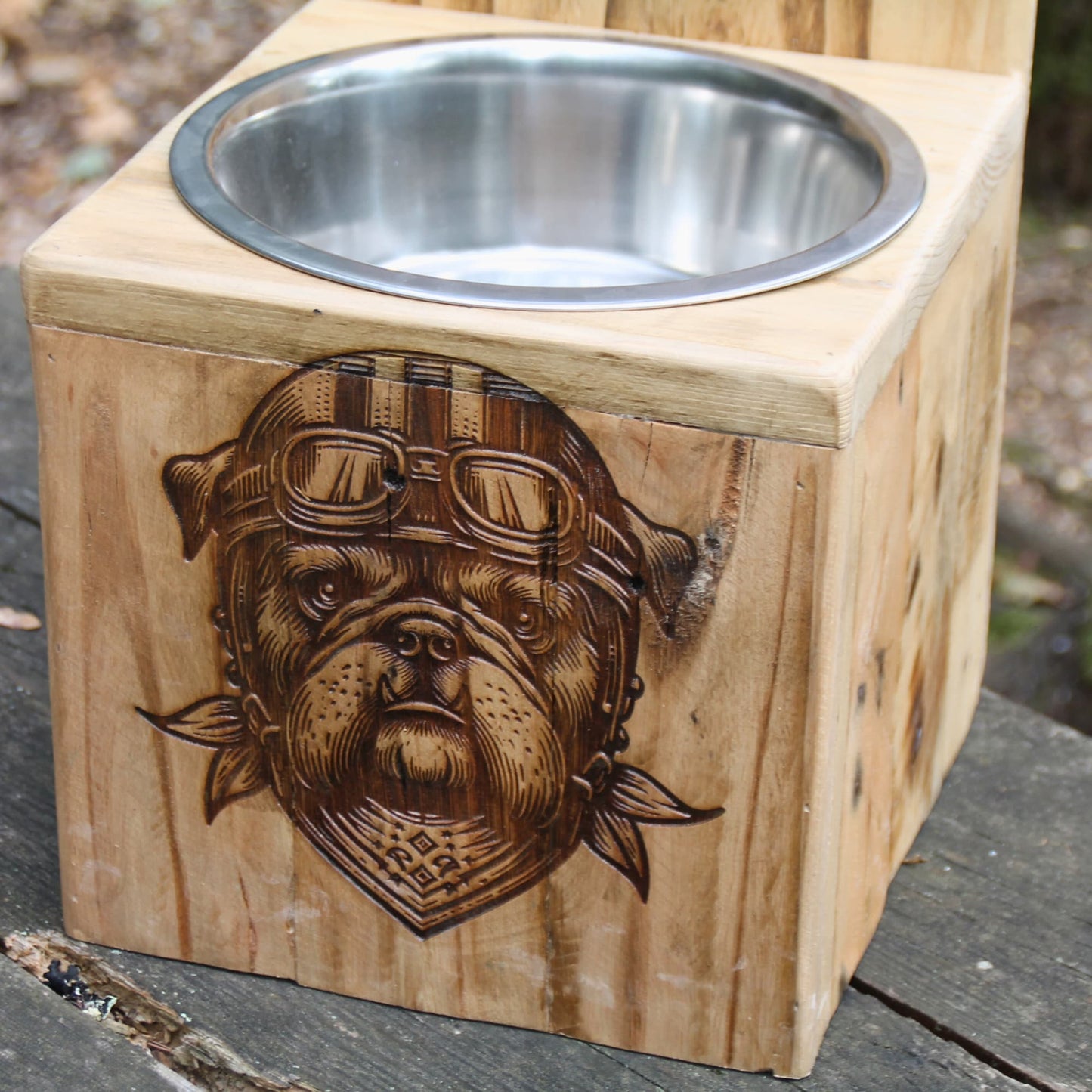 Gros plan sur la gravure de la façade : tête de chien motard avec casque, lunettes et foulard.