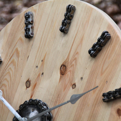Zoom sur les chaines de moto représentant les heures sur l'horloge en bois