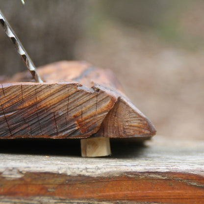 Socle en bois fruitier de l'horloge à poser. Cale en bois permettant d'équilibrer la forme naturelle du bois