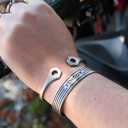 Joncs en acier inoxydable argenté, signés Rouille. Des bracelets au style industriel et audacieux.