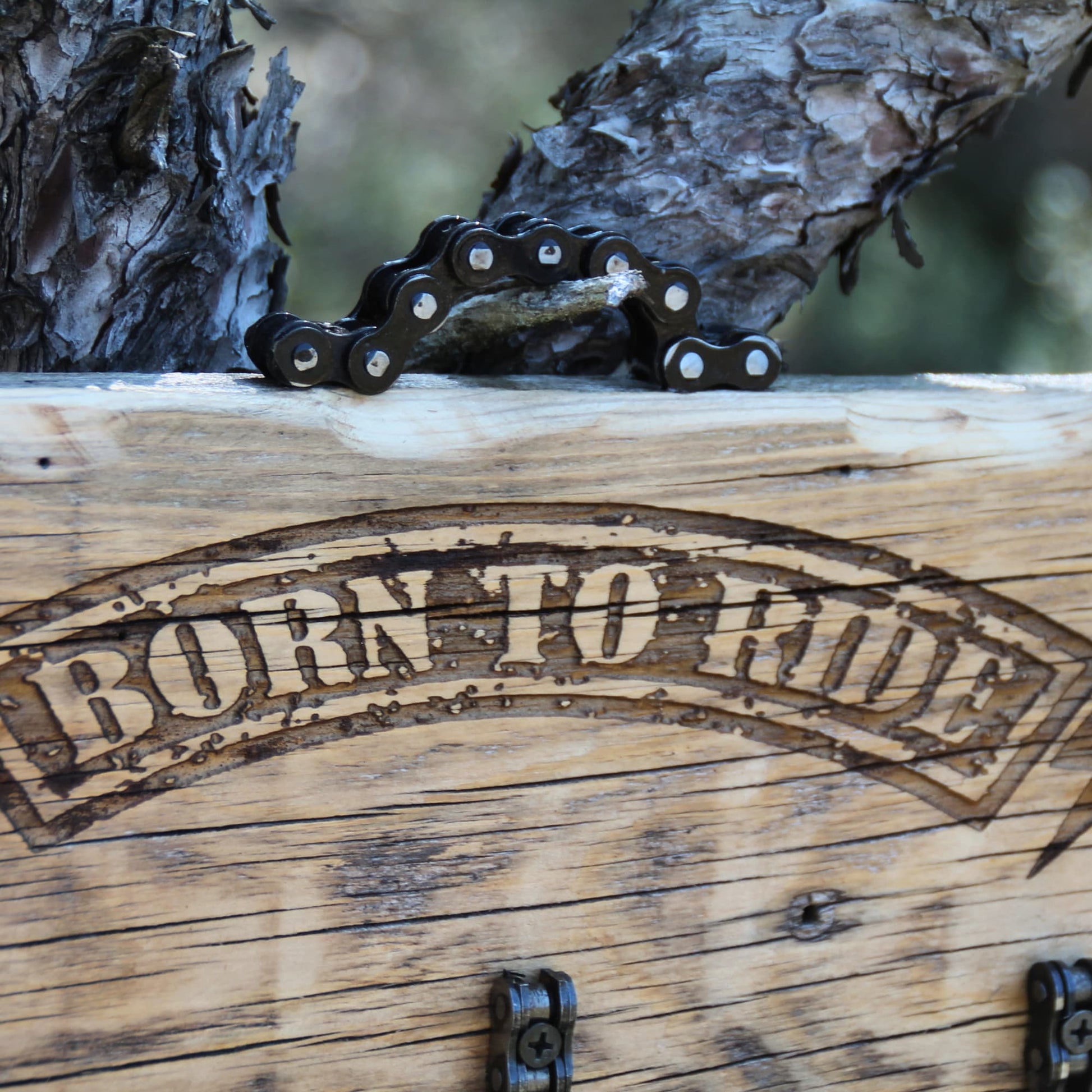 Détail de la gravure laser Born to Ride sur porte-clé mural en bois