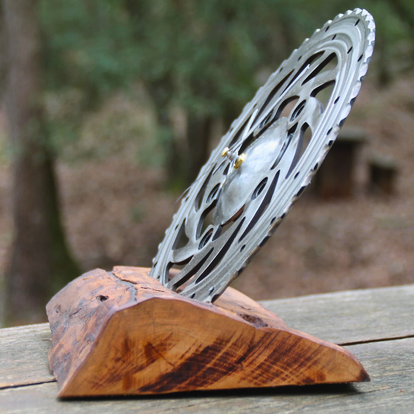 Horloge à poser en bois fruitier et disque de frein de moto vu de profil.