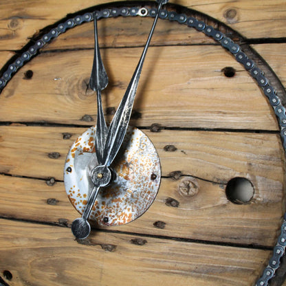 Zoom sur les aiguilles de l'horloge en bois de palette recyclé, mettant en avant le design artisanal et vintage.