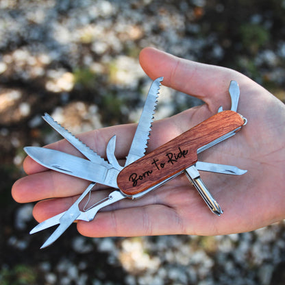 Couteau multifonction ouvert dans une main, affichant tous ses outils pratiques