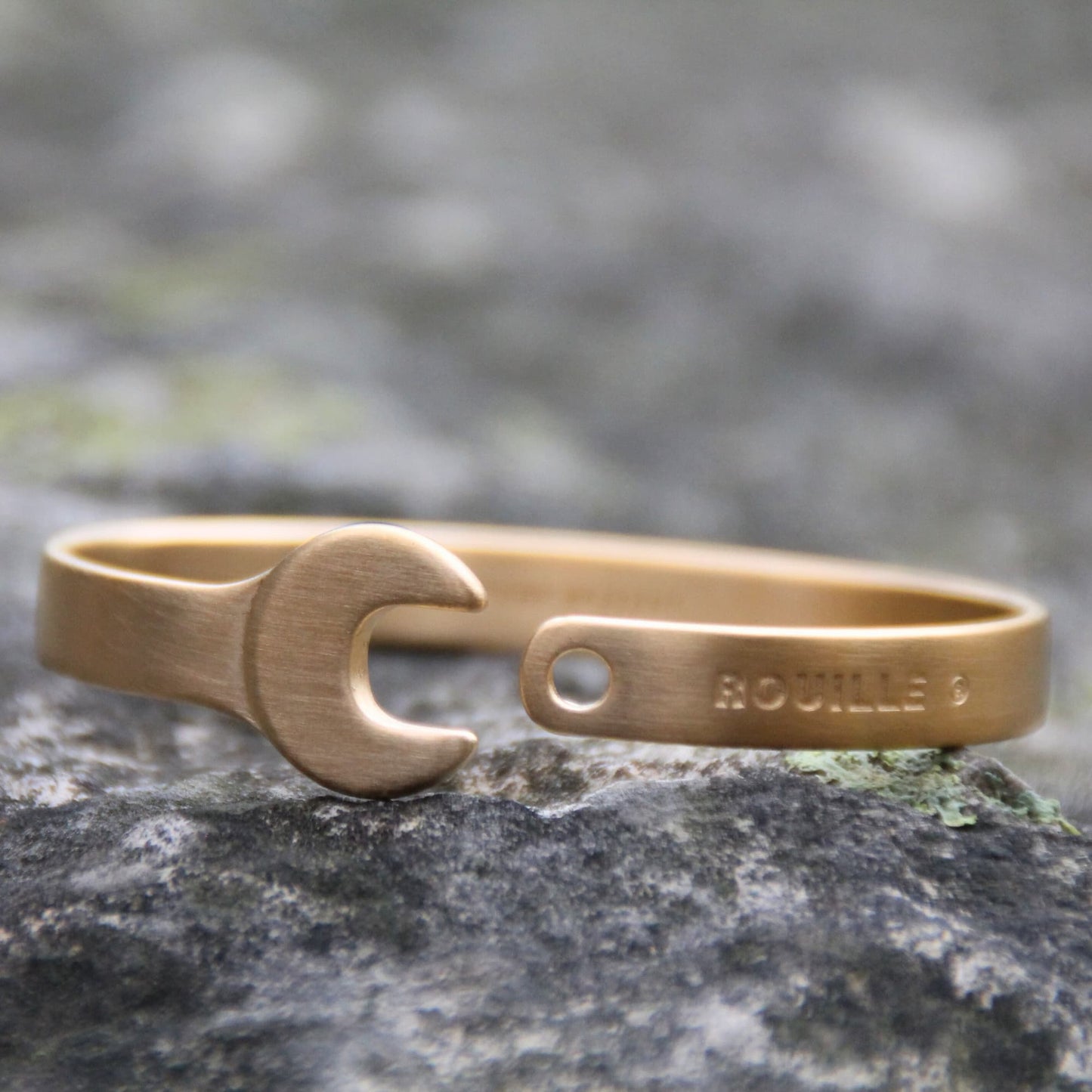 Bracelet jonc doré brossé en forme de clé plate.