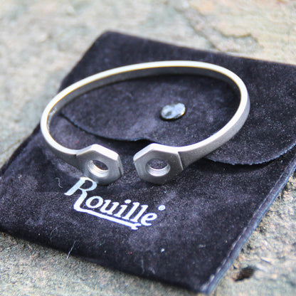 Bracelet jonc en acier inoxydable argenté, livré avec sa pochette en velours noir pour un rangement soigné.