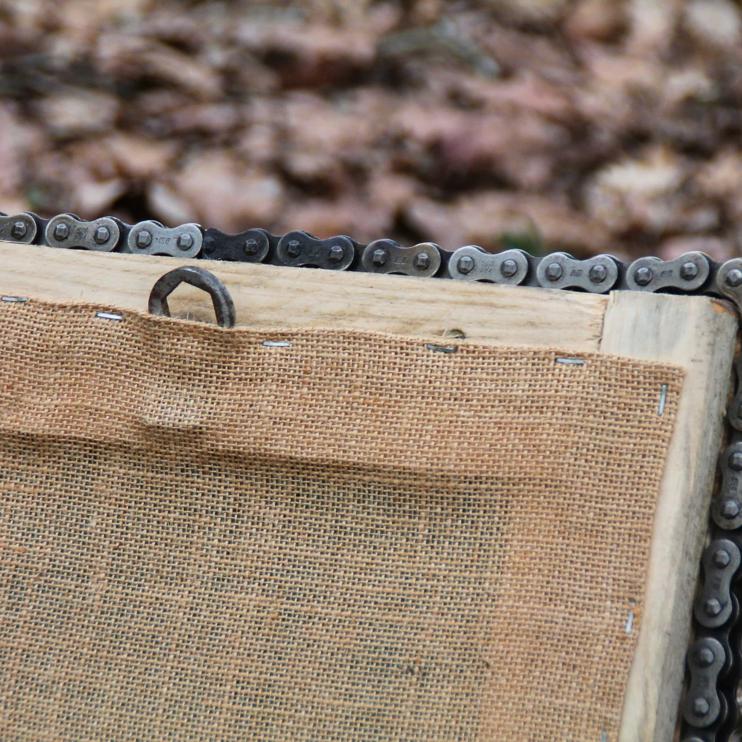 Dos du miroir artisanal en bois et chaine de moto. Zoom sur le crochet de fixation murale