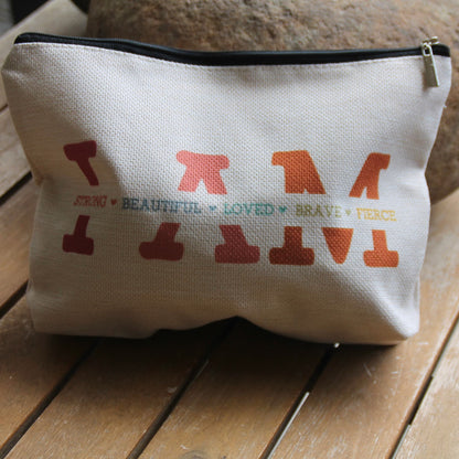Pochette Je suis forte, belle… remplie, avec imprimé rétro multicolore, accessoire pratique pour motarde.