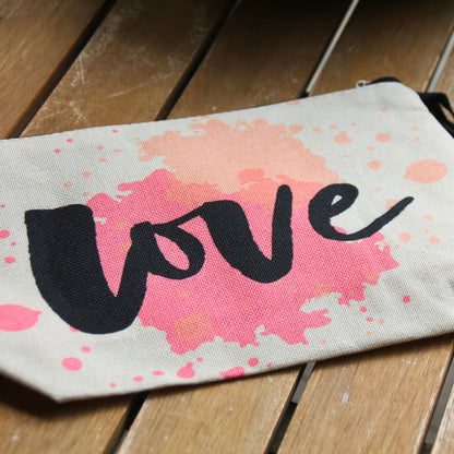 Pochette Love aquarelle rose corail posée à plat, idée cadeau originale pour motarde