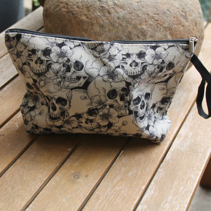Pochette motarde crânes et fleurs en polyester imitation lin avec dragonne et fermeture éclair
