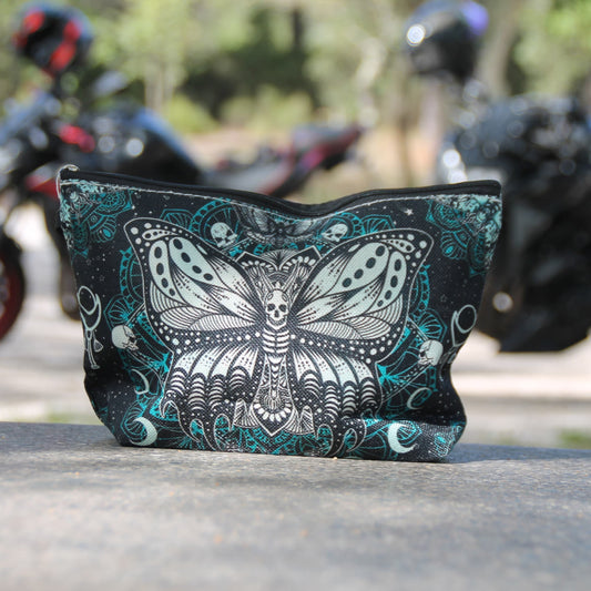 Pochette motarde Papillon Mandala noire et turquoise photographiée devant des motos