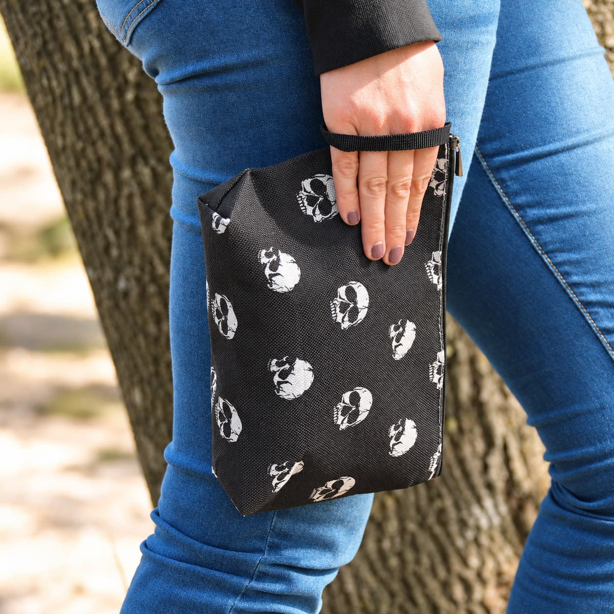 Accessoire rock pour motarde, pochette noire à crânes blancs avec dragonne.