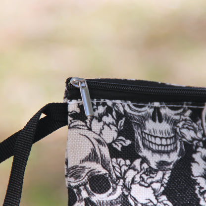 Détail de la fermeture éclair et de la dragonne noire de la pochette biker à crânes et roses.