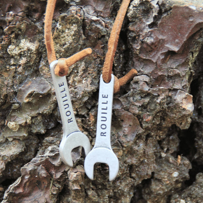 Porte-clés en métal en forme de clé à molette, finition vieillie et cordon en cuir – Accessoire unique et robuste.