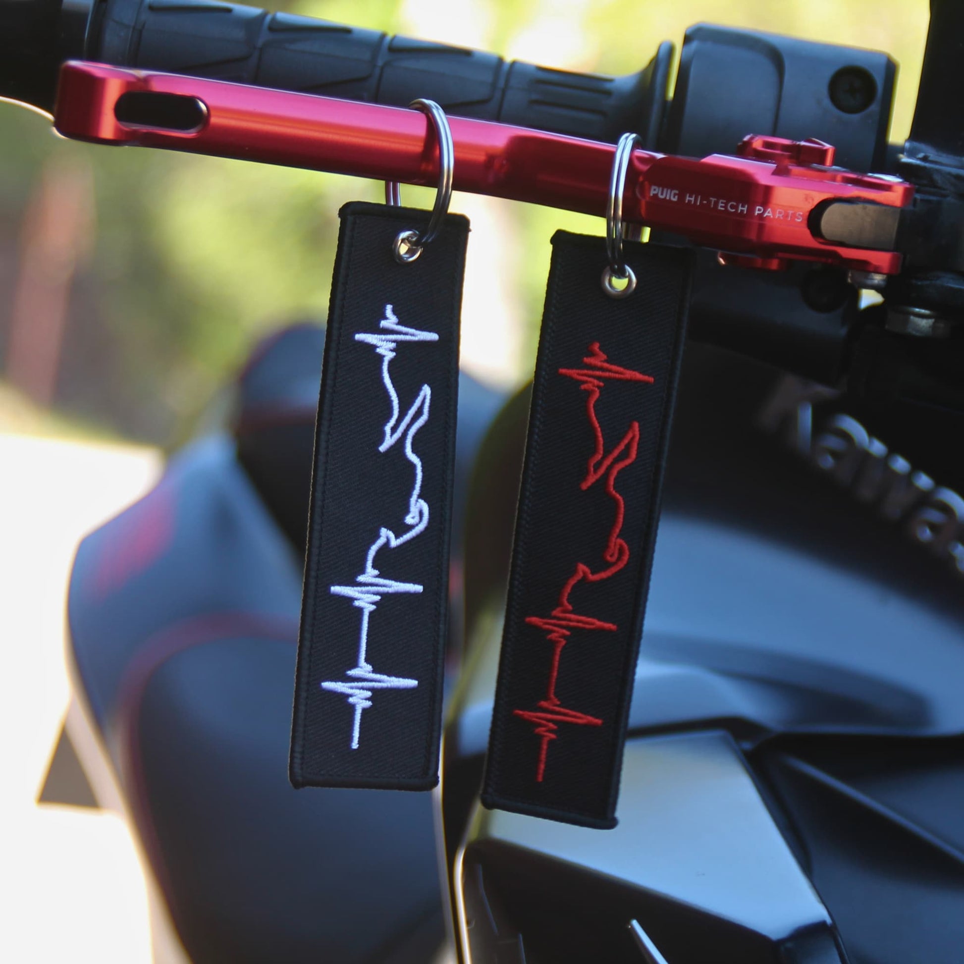 Porte clé moto ligne de vie rouge et blanc accrochés levier de frein