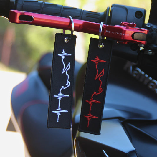 Porte clé moto ligne de vie rouge et blanc accrochés levier de frein