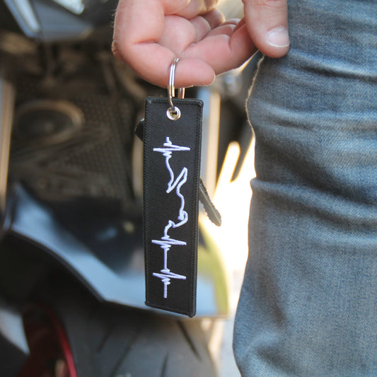 Porte clé motard blanc ligne de vie tenu à la main