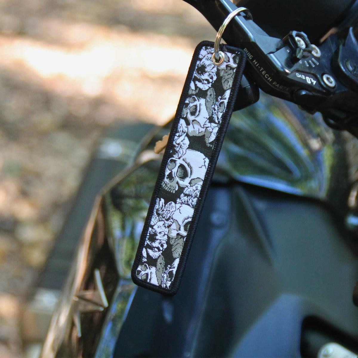Porte clé moto en tissu noir brodé de cranes et de fleurs. Une idée cadeau pas cher pour motard et motarde !