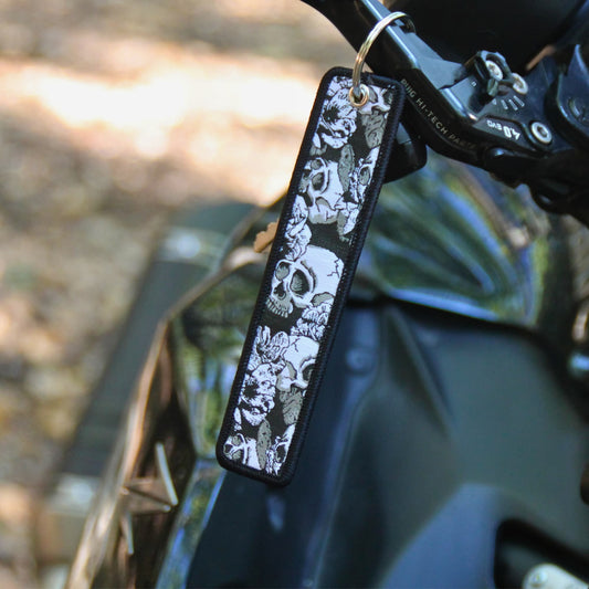 Porte clé moto en tissu noir brodé de cranes et de fleurs. Une idée cadeau pas cher pour motard et motarde !